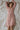 Light coral muslin cotton robe, relaxing on white linen sheets